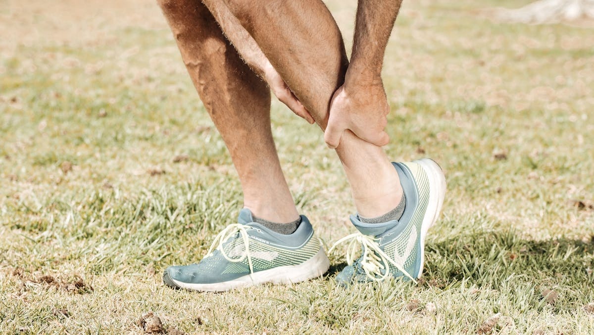 Sportif se tenant la jambe après une douleur musculaire au mollet