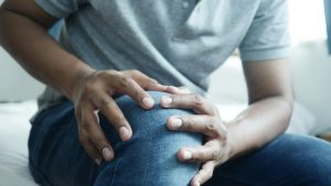 Personne tenant son genou douloureux avant rééducation