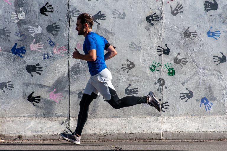 Coureur en foulee sollicitant le tendon d'Achille le long d'un mur urbain, suivi kine a Boulogne 2 Pau Casals.