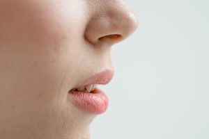 Gros plan de profil sur le nez et la bouche entrouverte d'une femme, respiration buccale visible.